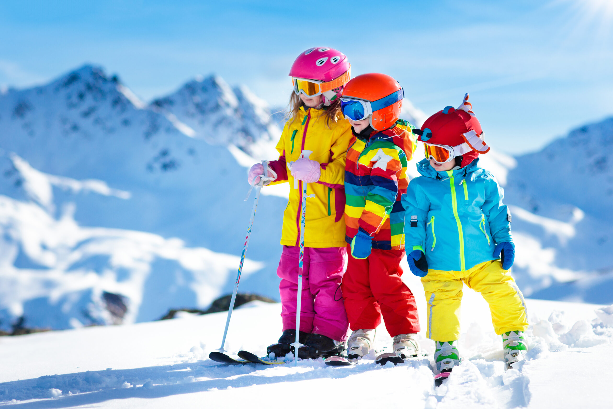 Children in bright colored clothing on a ski slope