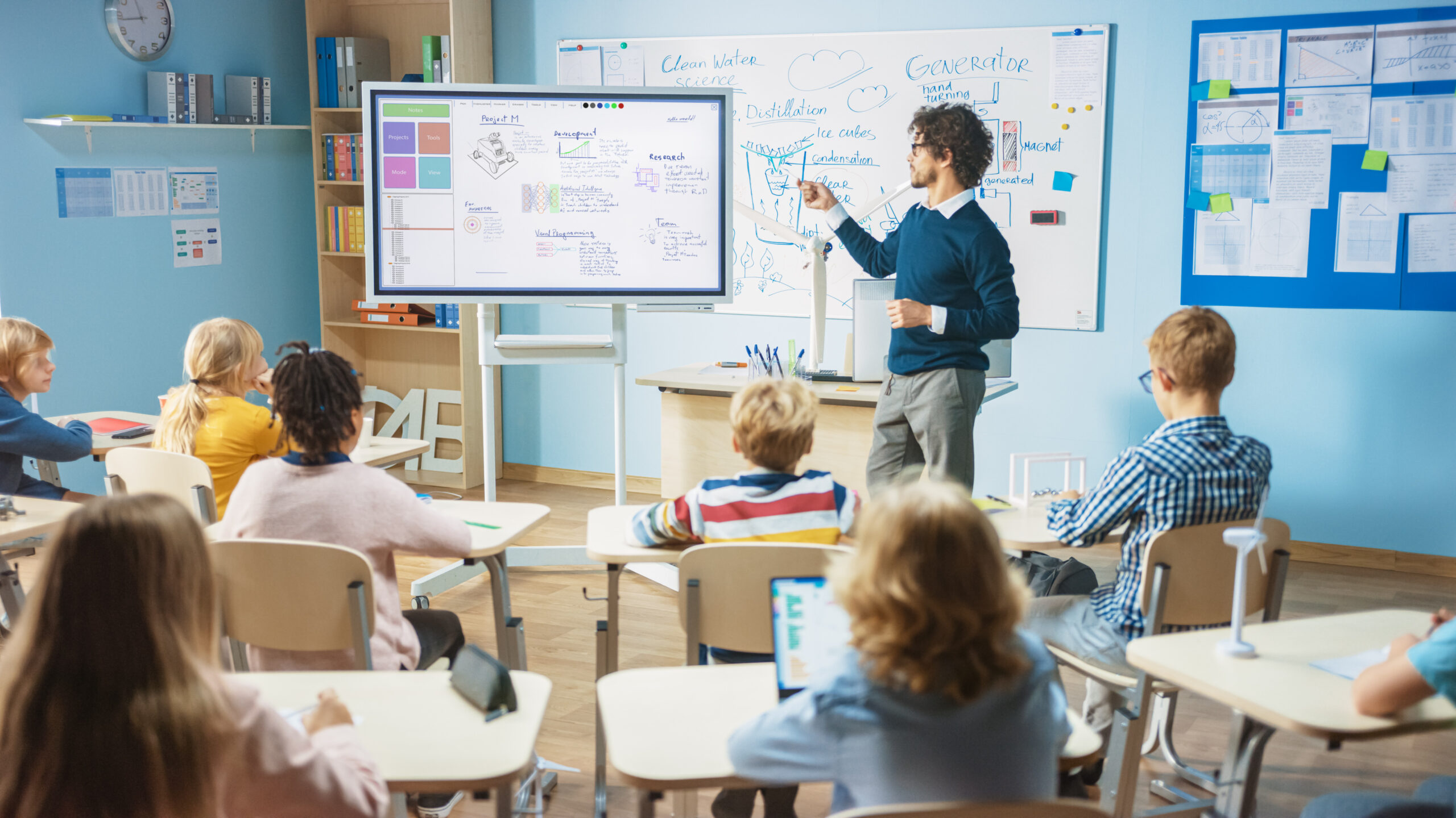 a teacher points at a whiteboard with a laser pointer