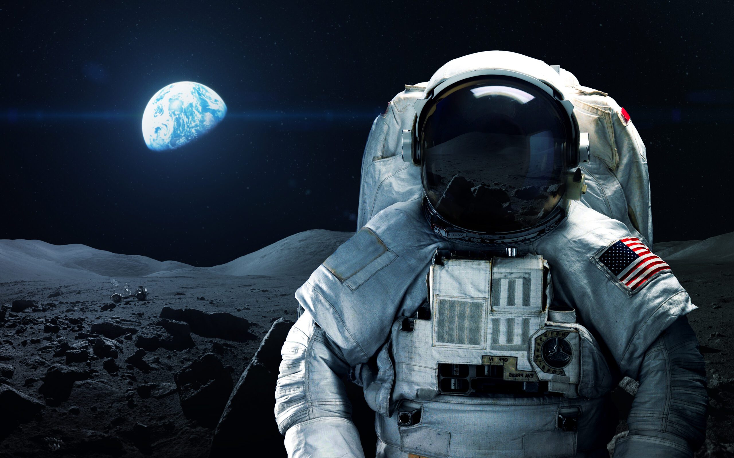 An astronaut on the moon with earth over their right shoulder